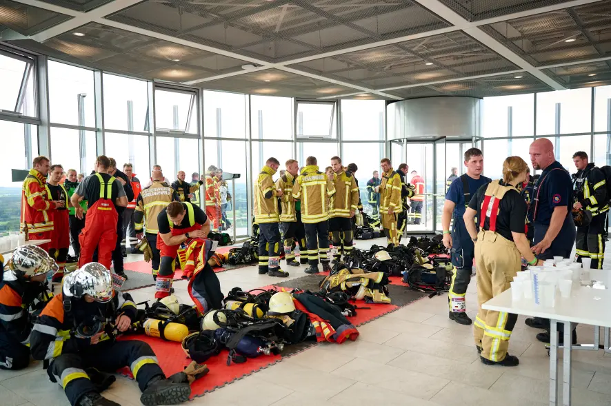Erschöpfte Feuerwehrleute nach dem Besteigen von 1390 Stufen auf der Besucherplattform